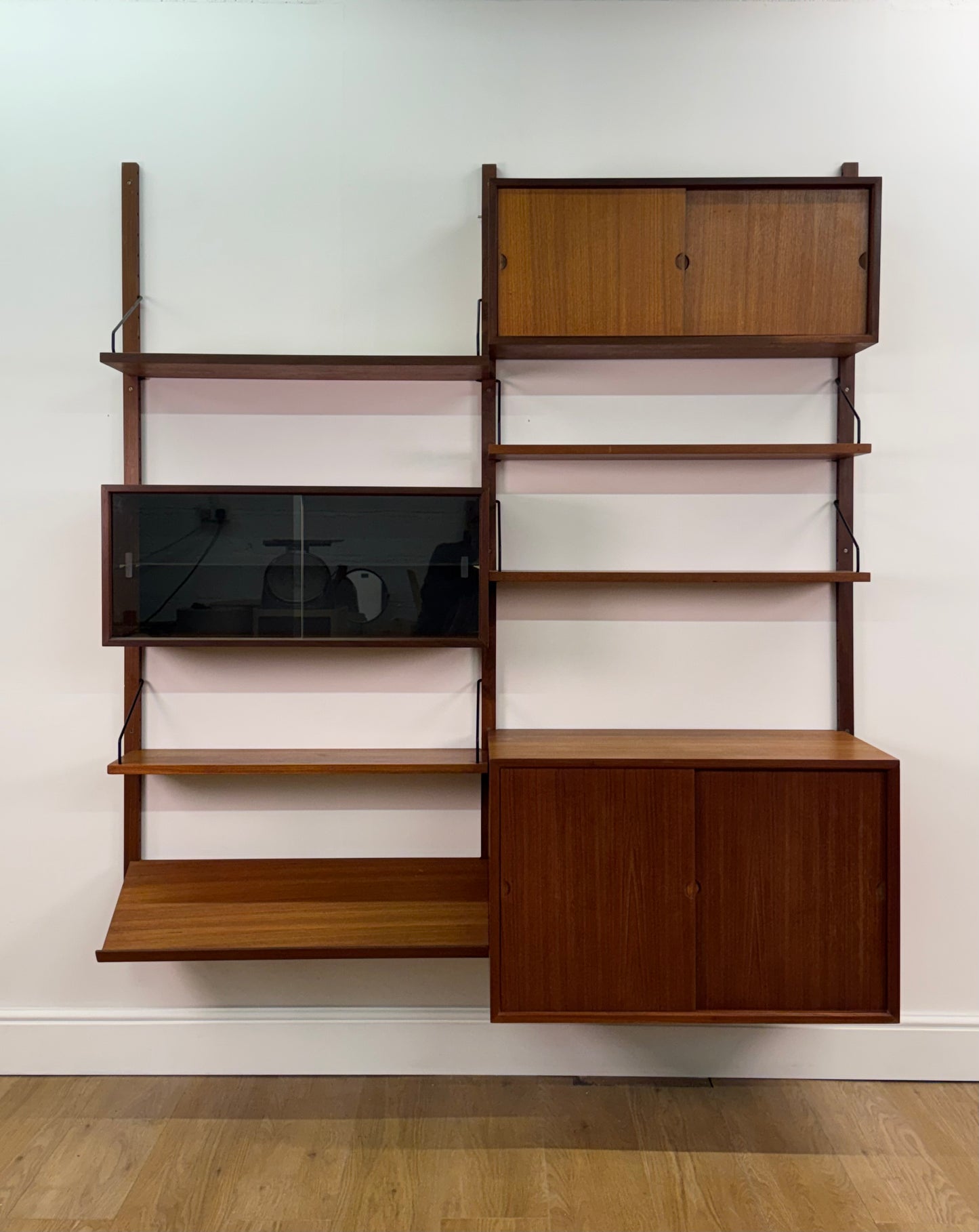 Danish teak wall mounted shelving system by Poul Cadovious