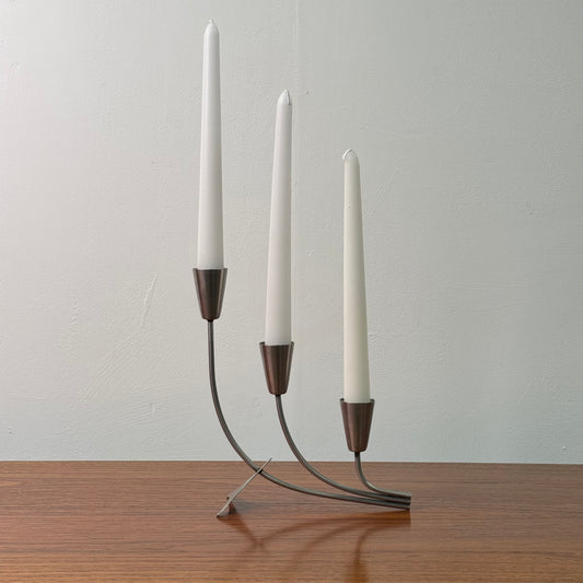 A stainless steel modernist candlestick