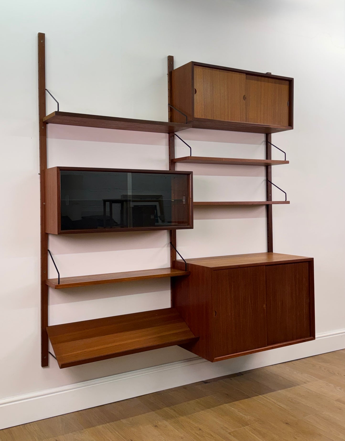 Danish teak wall mounted shelving system by Poul Cadovious