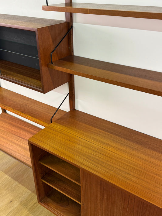 Danish teak wall mounted shelving system by Poul Cadovious