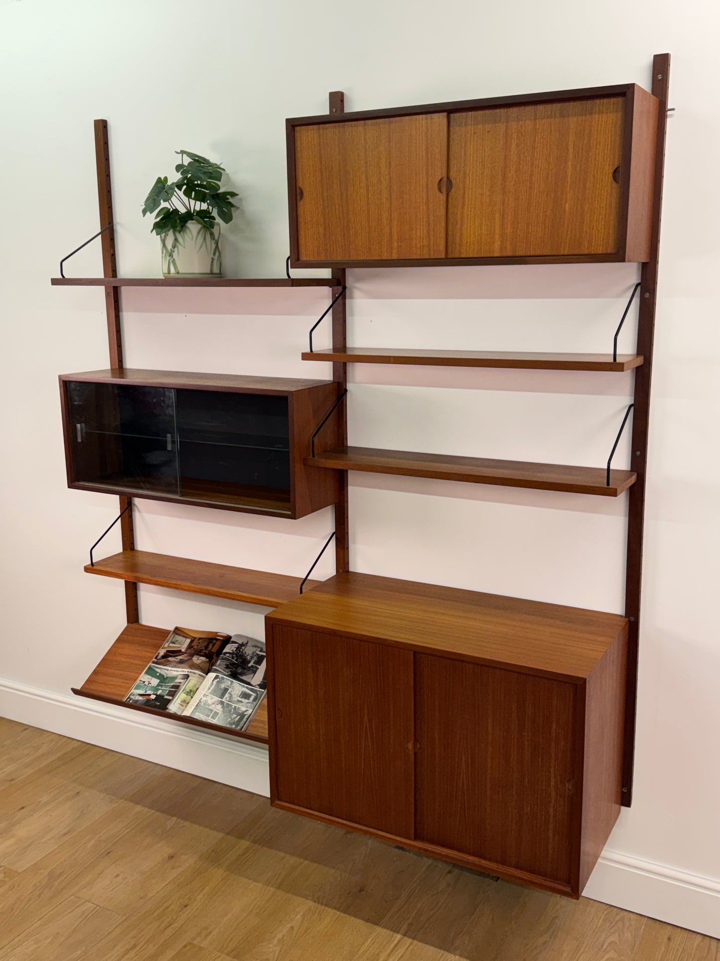 Danish teak wall mounted shelving system by Poul Cadovious
