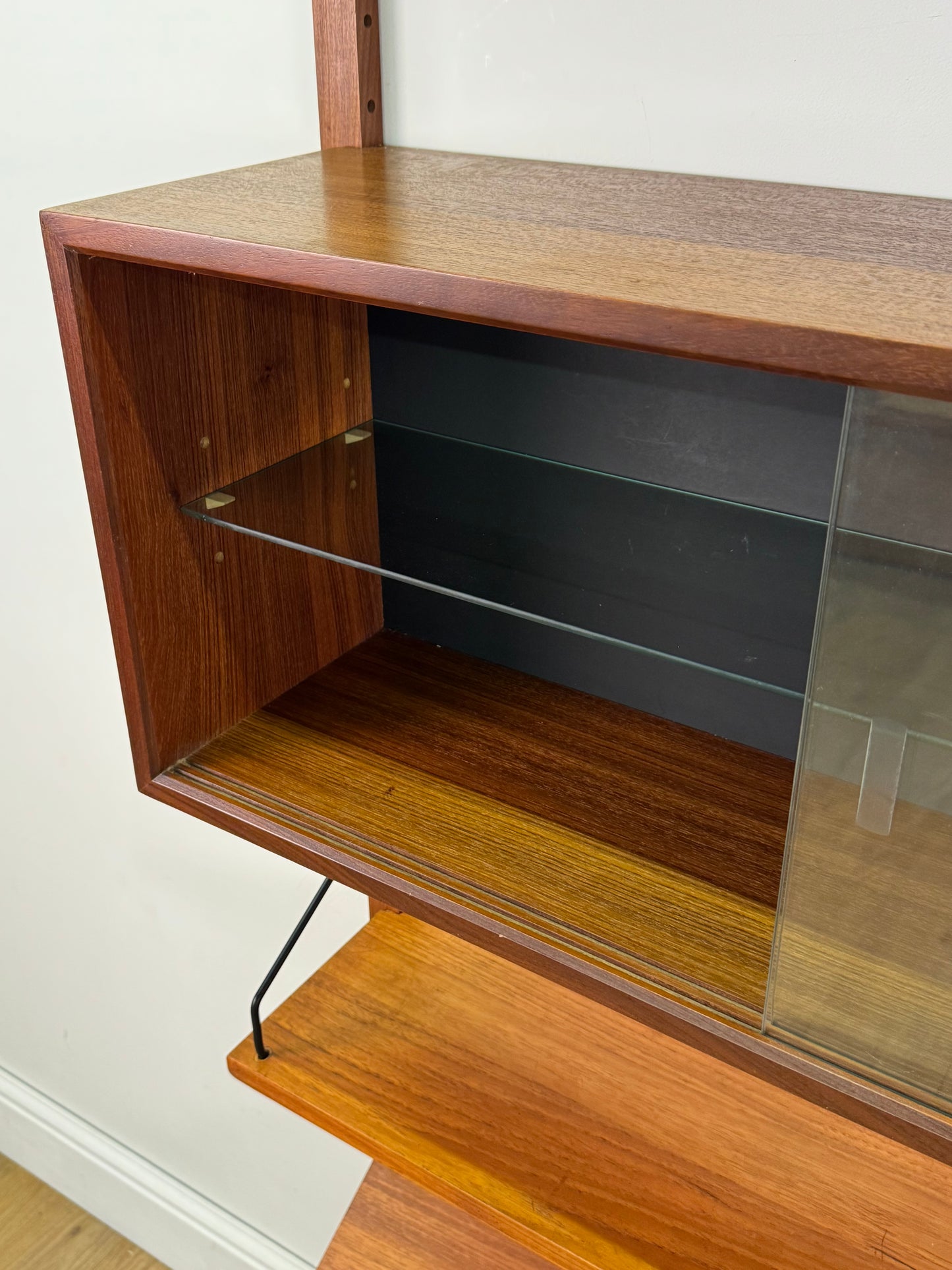 Danish teak wall mounted shelving system by Poul Cadovious